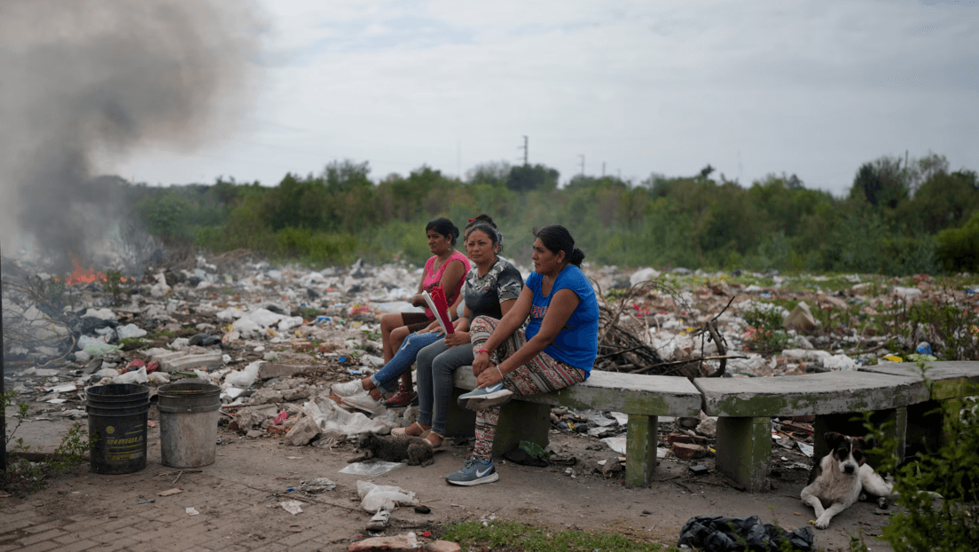 Mujeres se reúnen mientras observan cómo se quema basura cerca de sus casas en Tucumán, Argentina, en 2023. Natacha Pisarenko